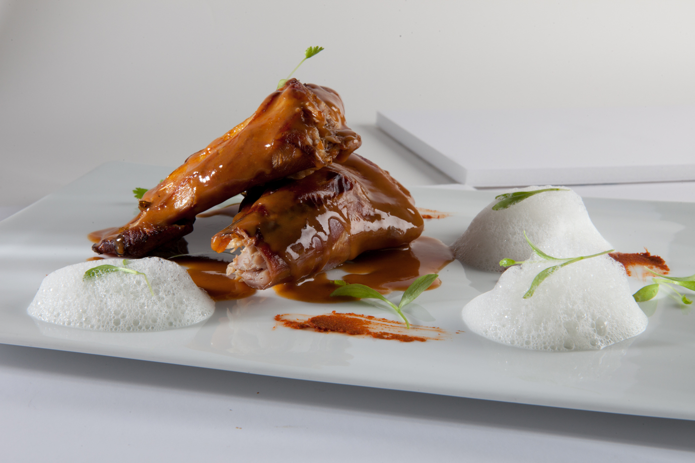 Paletilla de cordero Thai con aire de su leche y germinado de cilantro