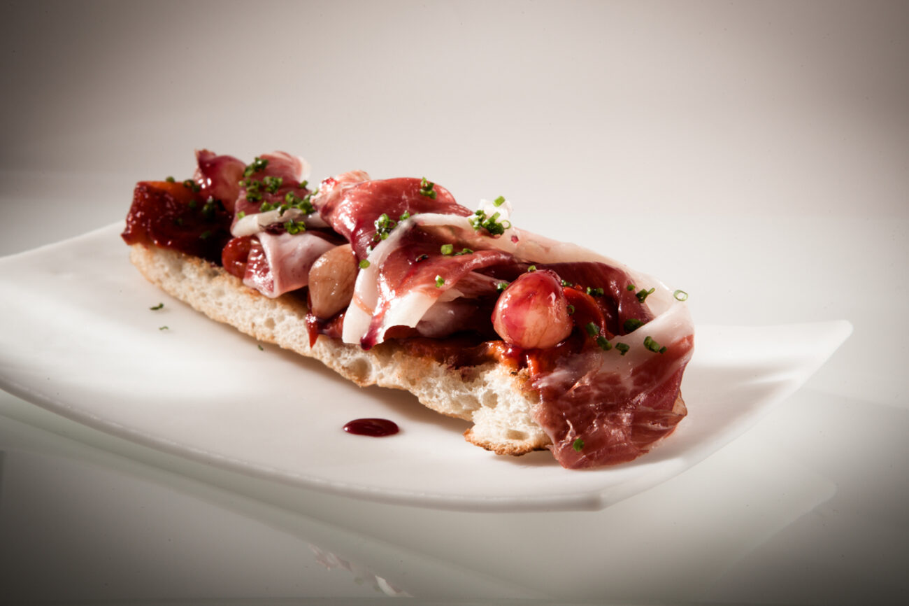 Coca de jamón de bellota 100% ibérico, pimientos asados y cebollitas encurtidas