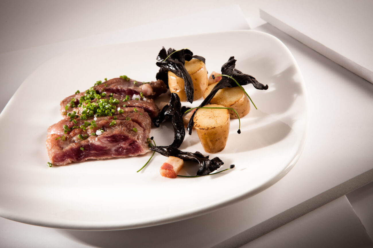 Secreto ibérico con patatas ratte y trompeta de los muertos