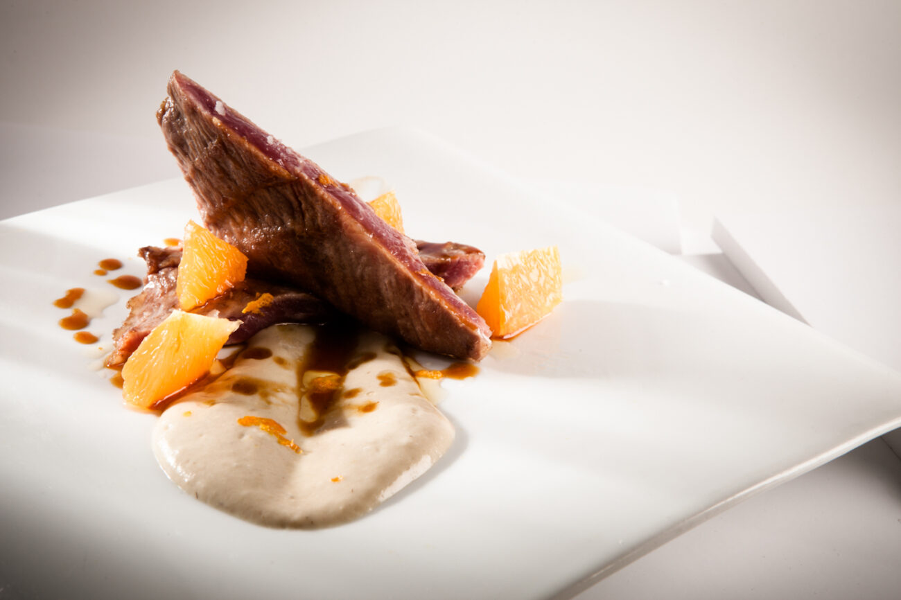 Secreto ibérico con puré de alcachofa y salsa de naranja