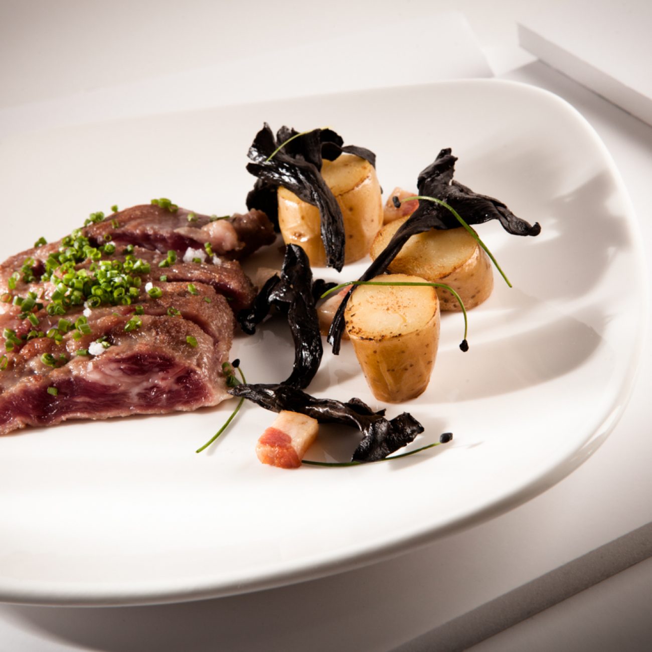 Secreto ibérico con patatas ratte y trompeta de los muertos