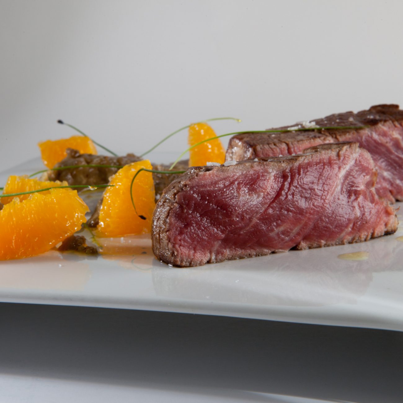 Solomillo Ibérico a la brasa con berenjenas a la llama y naranja